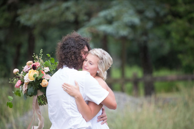 The bride and groom hugging in the field