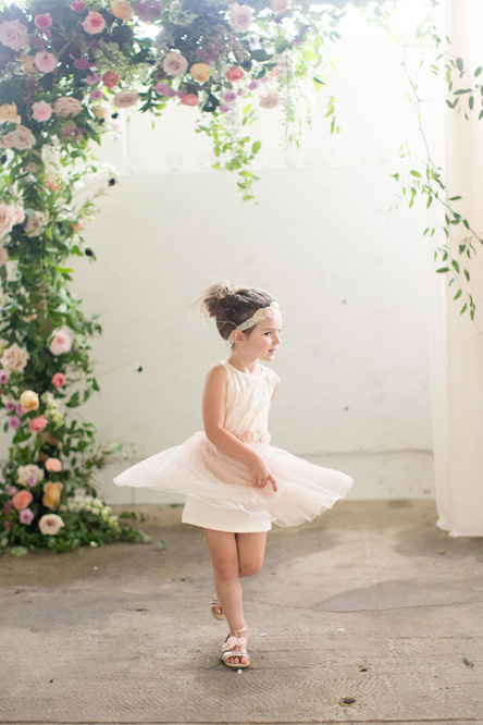 The flower girl beside the floral arch