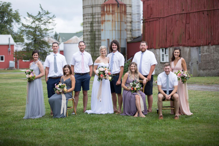 The wedding party in front of the red barn