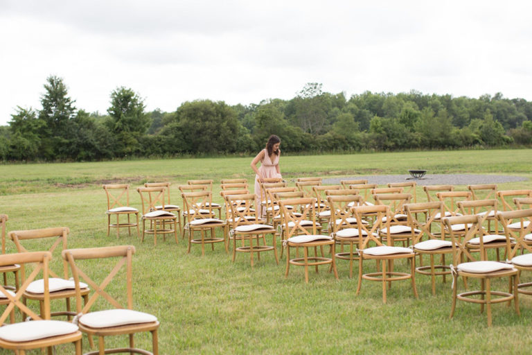 Rows of wooden chairs set out in the meadow for the ceremony