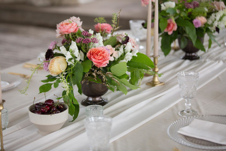 Table flowers beside a bowl of cherries