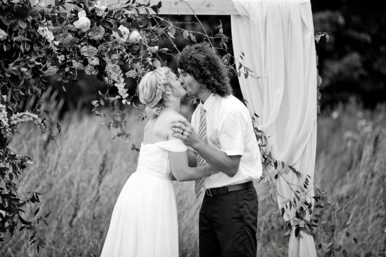 Black-and-white photo of the couple in tall grass
