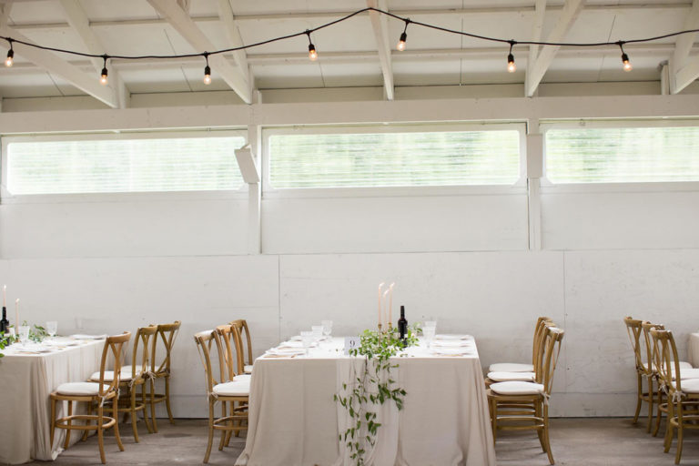 The long barn set for dinner beneath its high windows