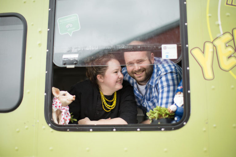 The couple leaning out of a food truck window