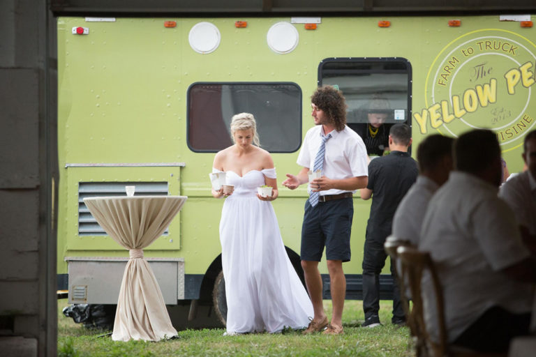 The bride and groom by the food truck with guests