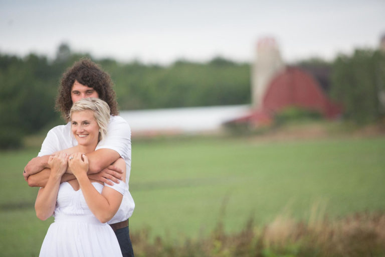 The groom with a young guest by the red barn