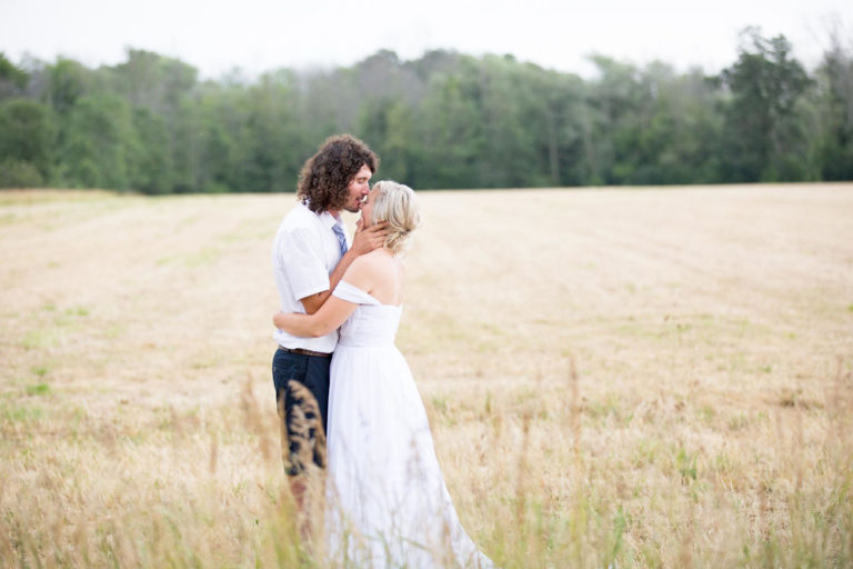 The bride and groom embracing in the golden field