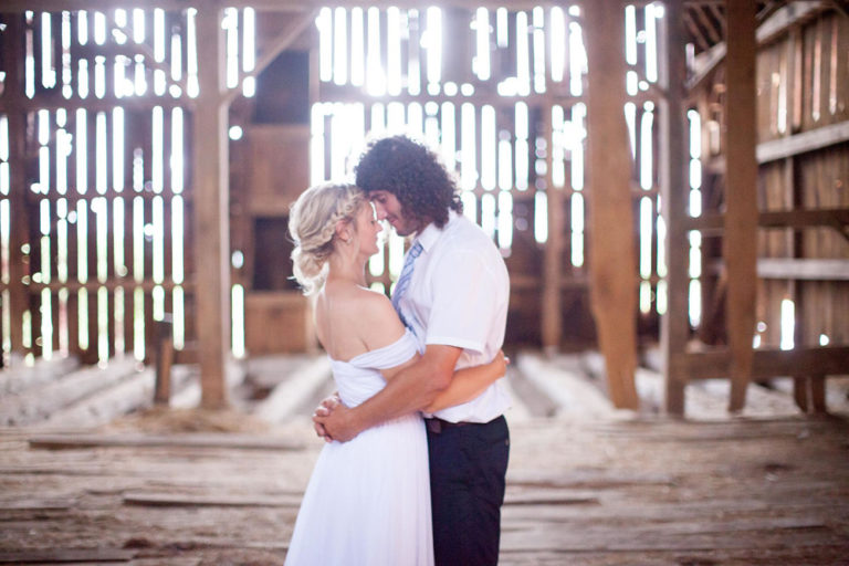 The bride and groom in the old timber barn